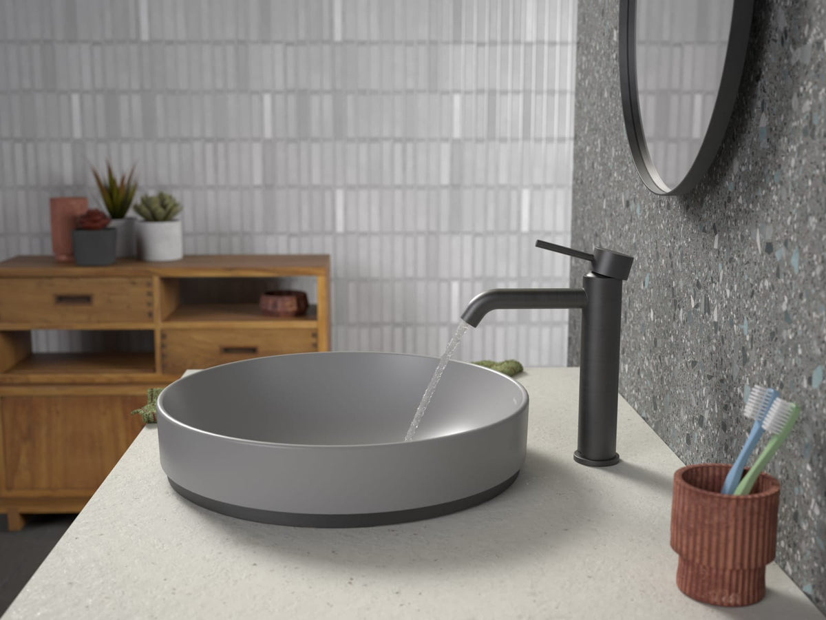 Round grey above counter basin on a stone benchtop with a black tall basin mixer