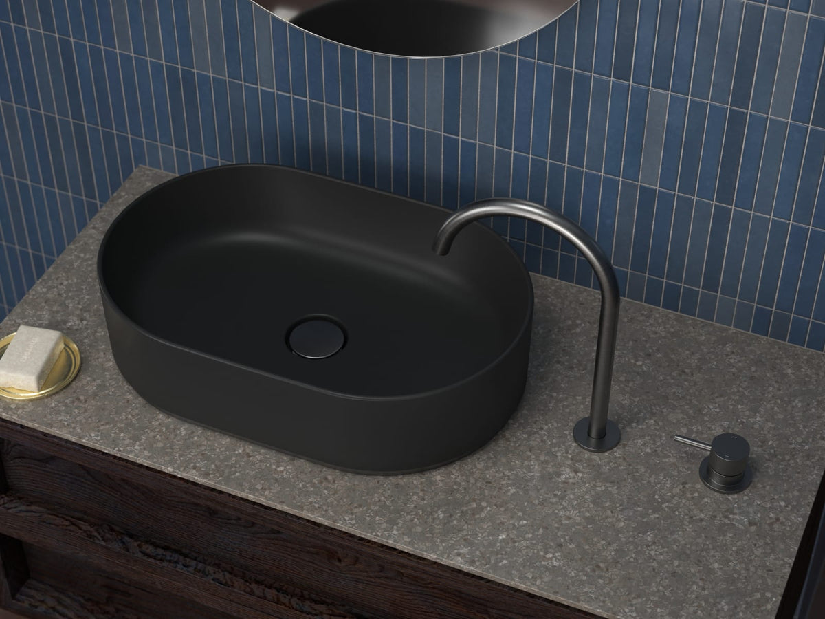 Gunmetal basin spout and hob mixer on a stone vanity against blue tiles