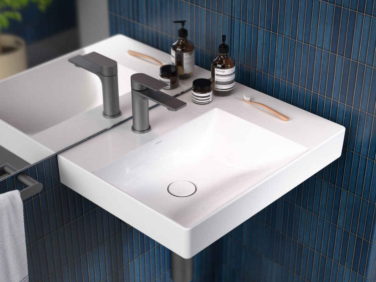 Rectangular wall hung basin with a chrome basin mixer against blue tiles