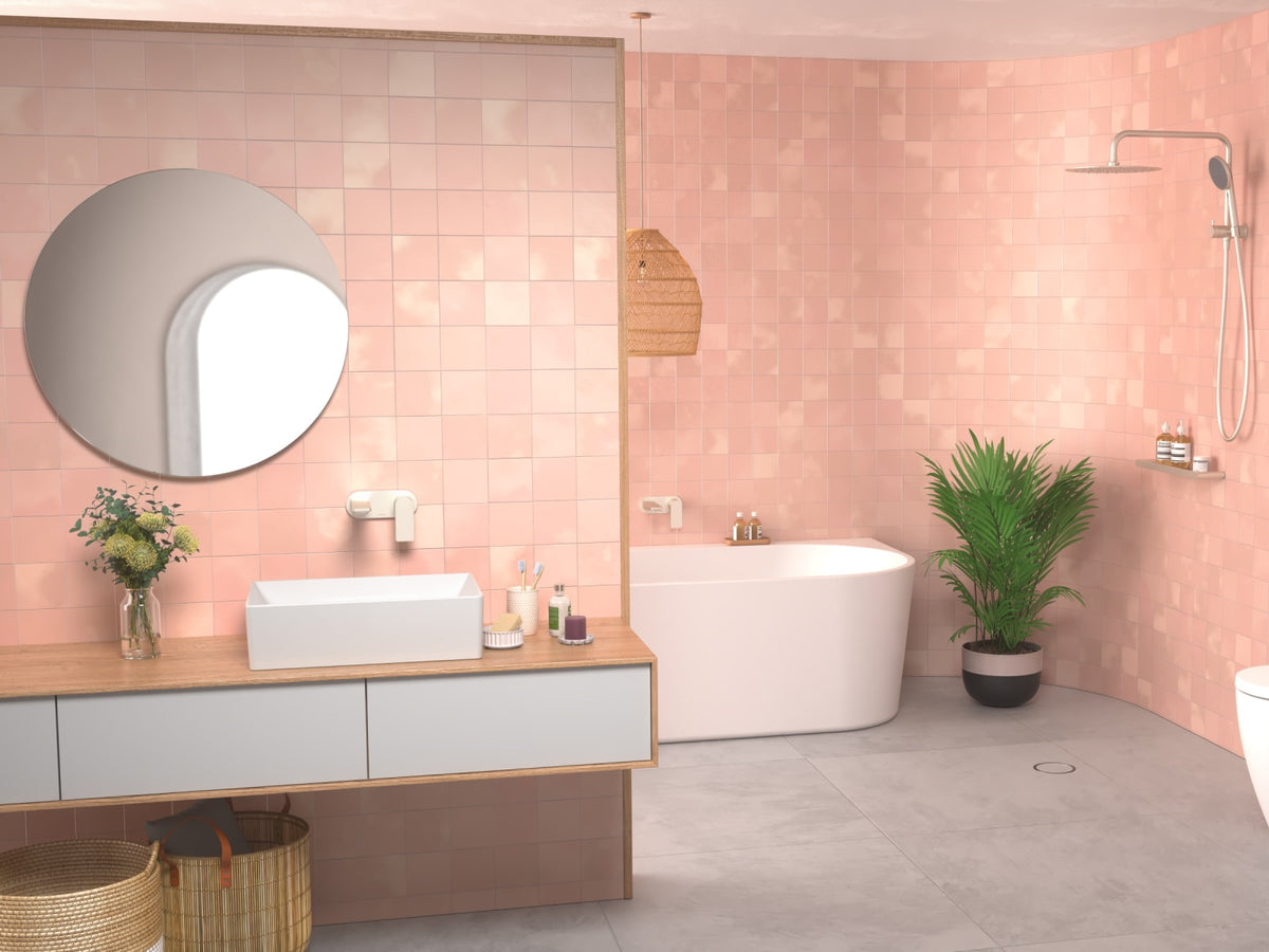 Pink tiled bathroom with tapware, freestanding bath, basin and toilet suite