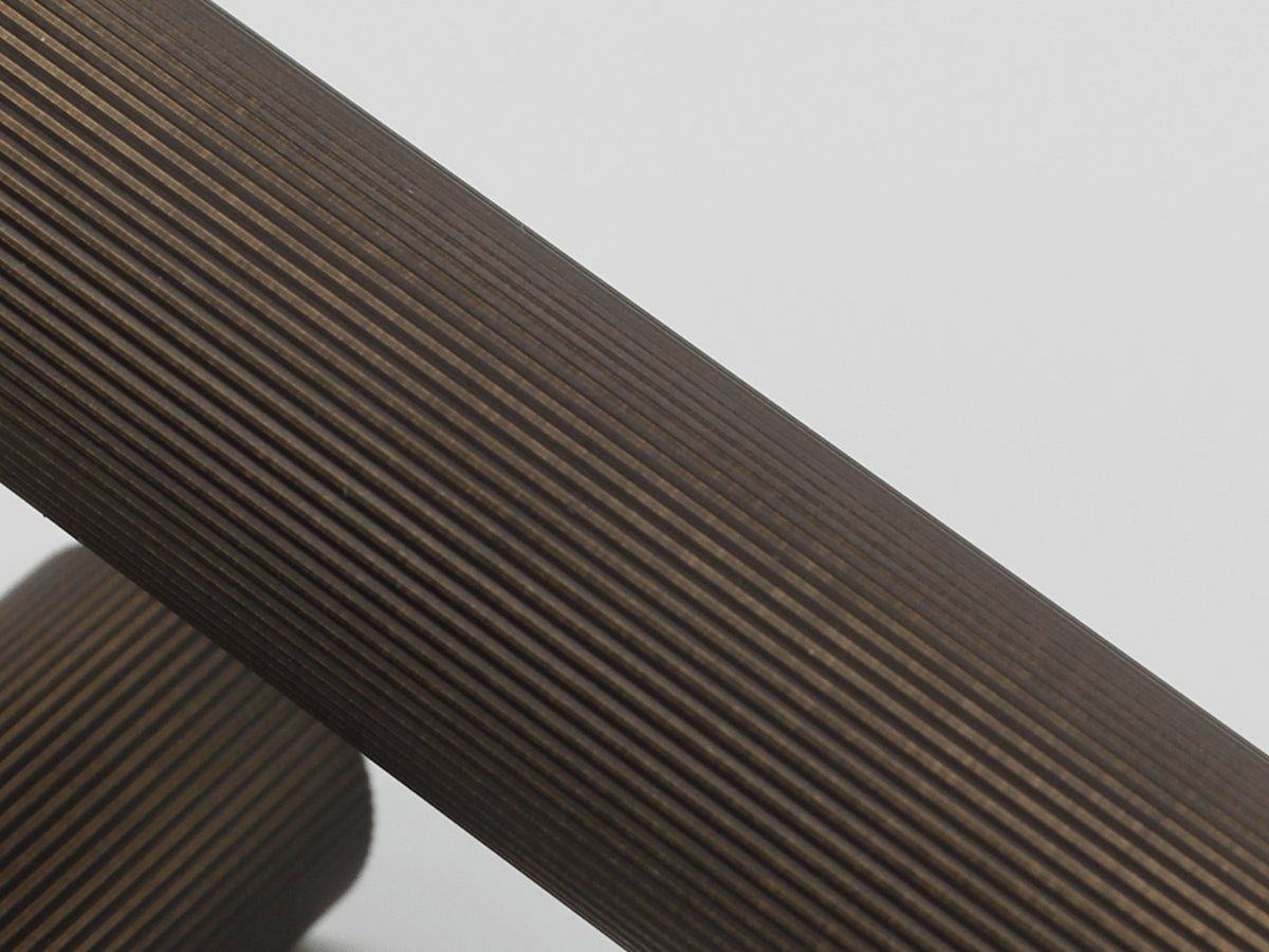 Close-up of Zephra Linear fluted door handle in Aged Bronze