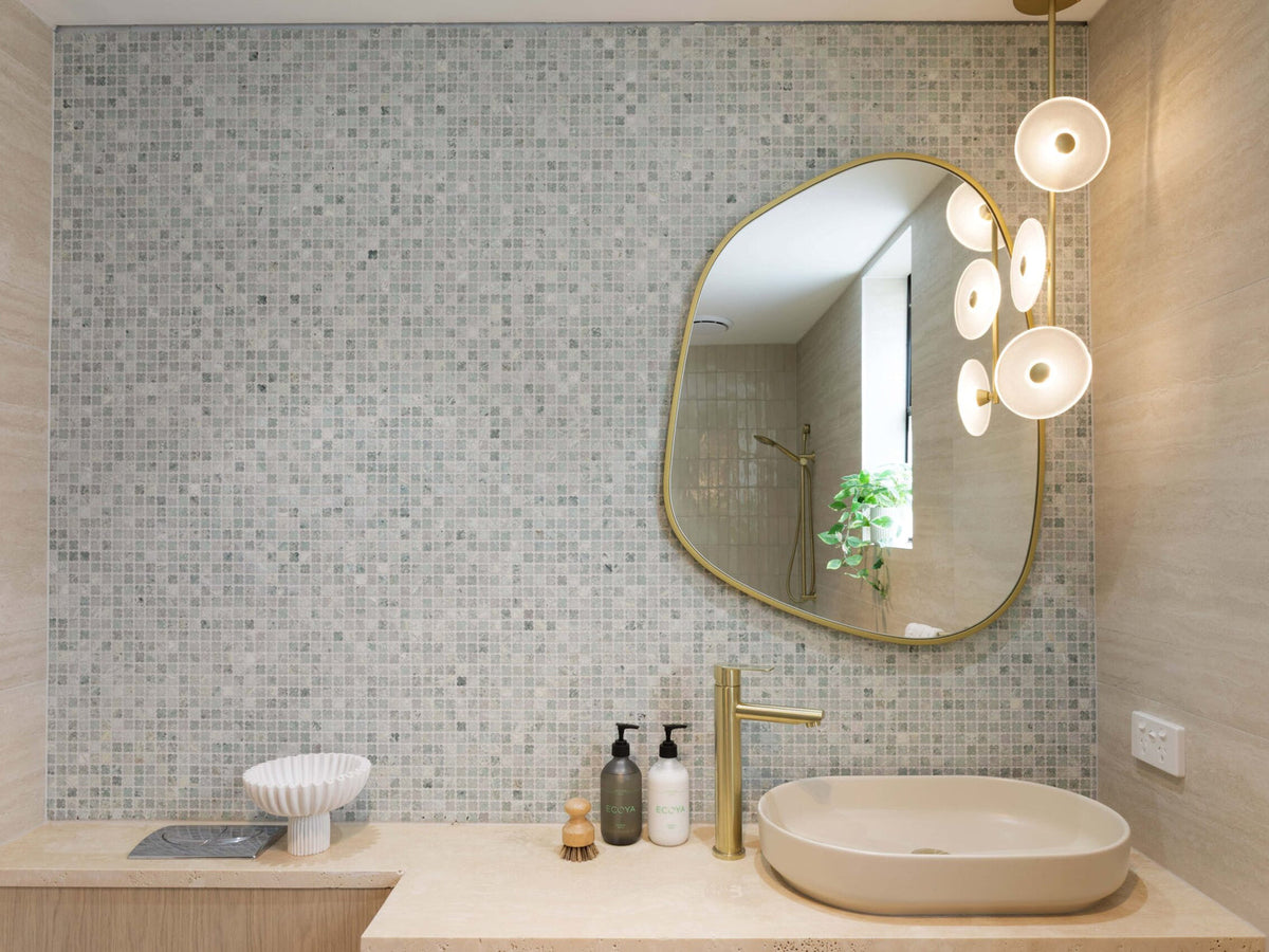 Soft Stone Sanctuary powder room with Alhambra Flower mosaic wall, organic mirror and stone basin