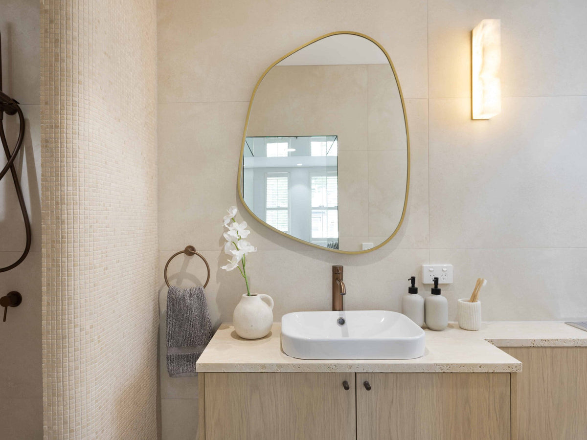 Soft Stone Sanctuary bathroom by Design Tiles with travertine-look porcelain walls, timber vanity and arched mirror