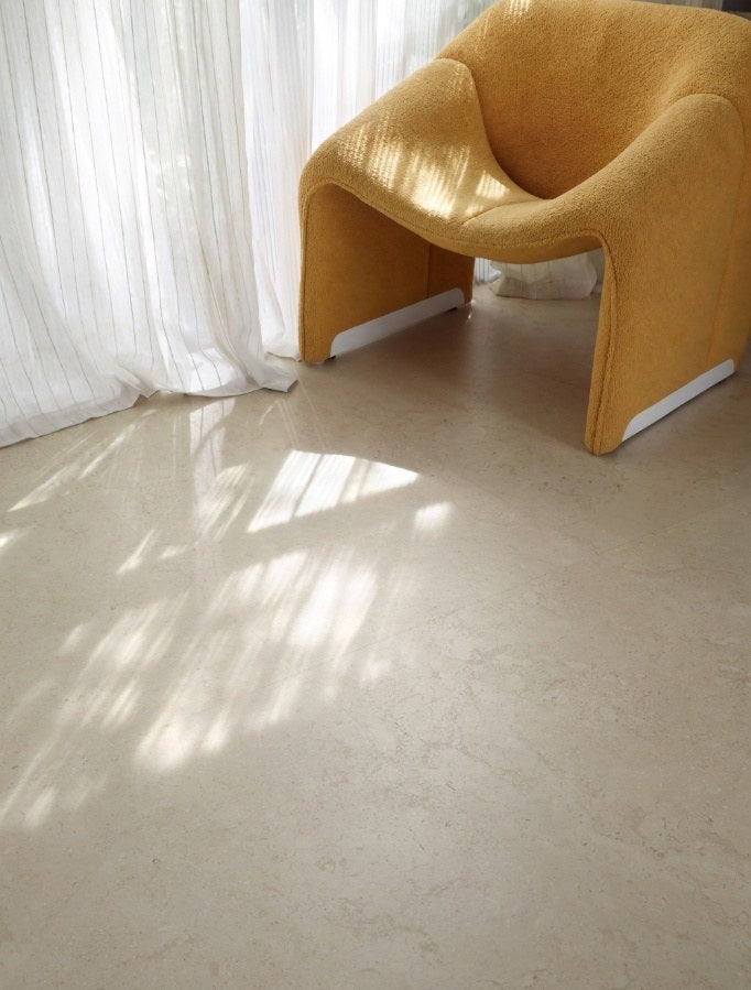 Luberon Beige limestone look porcelain floor in a sunlit living room with a mustard armchair