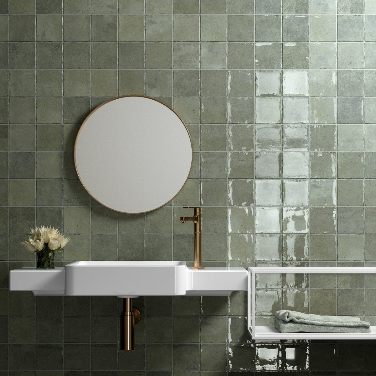 Sage green gloss Spanish square tiles across a bathroom wall with a round mirror and wall-hung basin