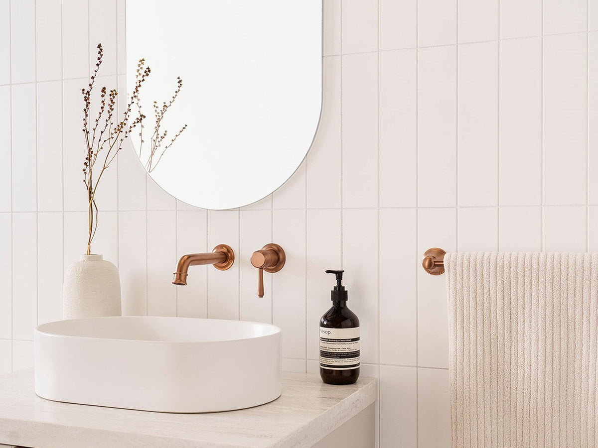 ADP brushed copper wall mixer and spout above an above-counter basin