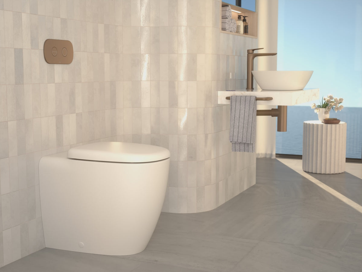 Toilet suite and fluted basin with brushed brass bathroom accessories