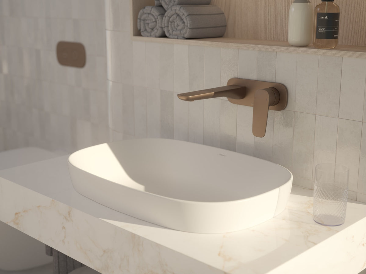Wall mounted basin mixer in a warm bronze finish above a stone benchtop basin