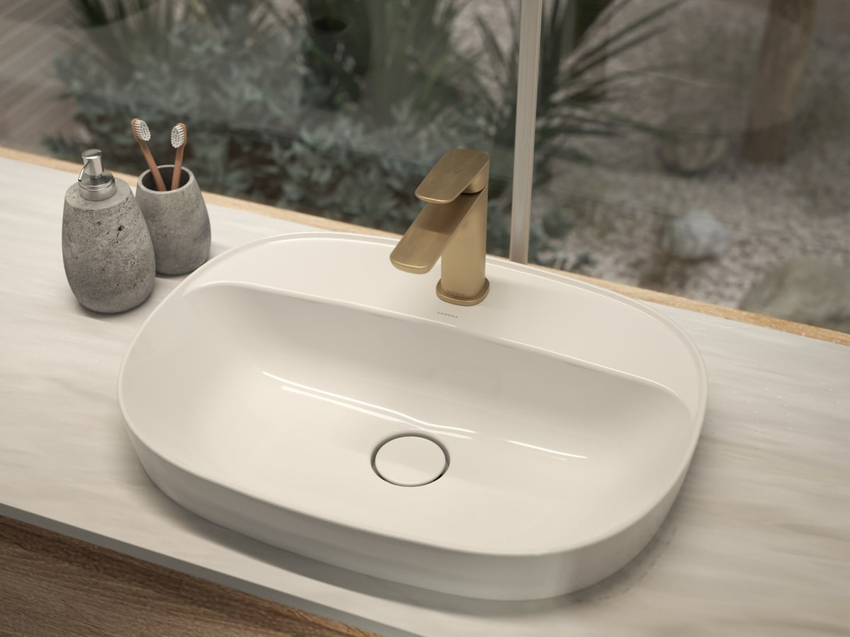 Inset basin on a stone benchtop with a brushed brass basin mixer