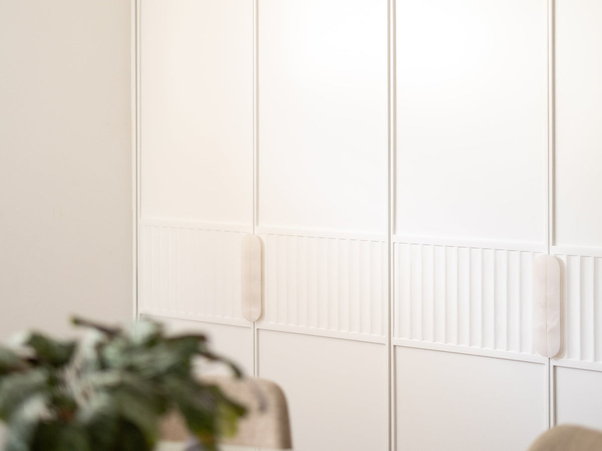 White Onyx stone cabinet pulls installed on fluted white joinery
